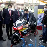 El presidente de la Junta de Andalucía, Juanma Moreno (c), monta en una moto del UMA Racing Team fabricada en la Universidad de Málaga. EFE/Daniel Pérez