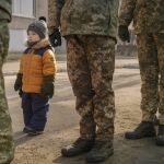 Un niña imita la posición marcial de un soldado de Ucrania en Luhansk, al este del país