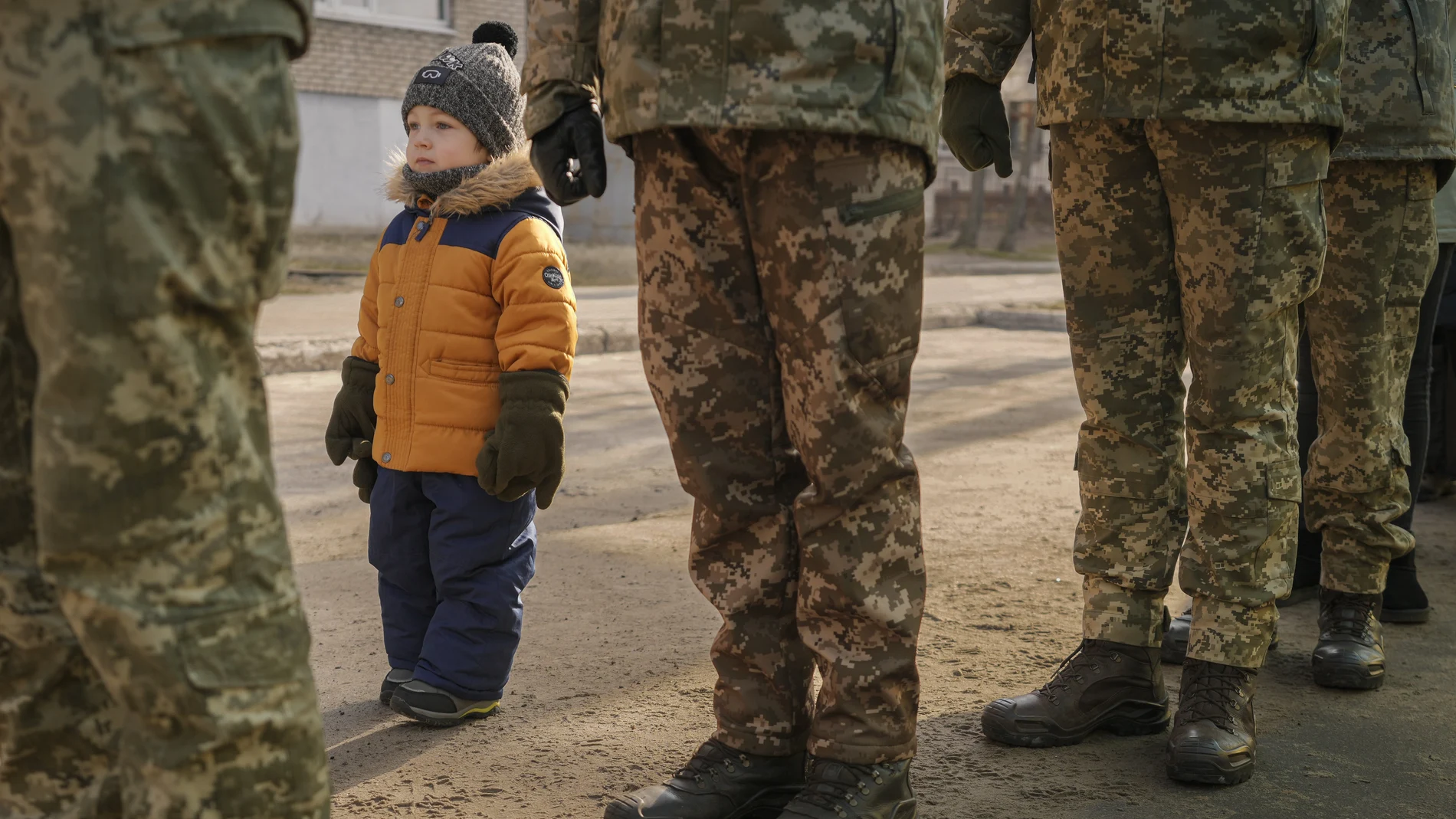 Un niña imita la posición marcial de un soldado de Ucrania en Luhansk, al este del país
