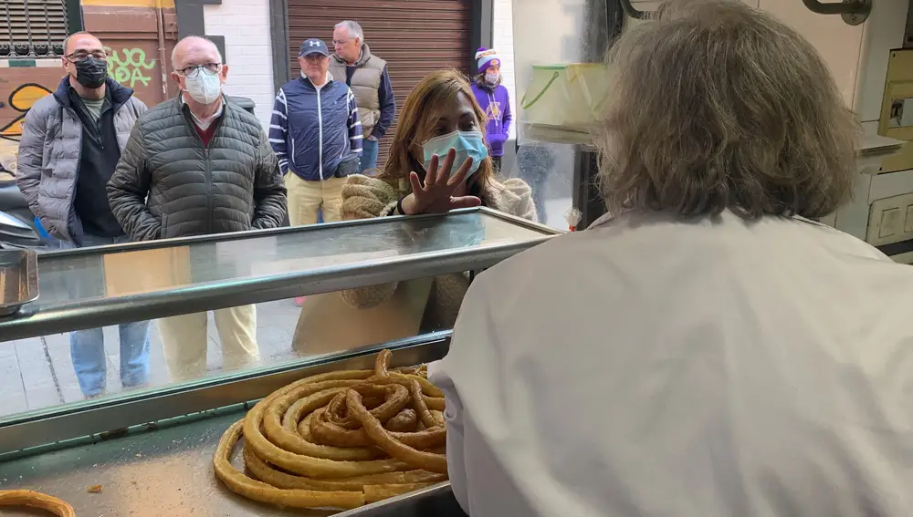 Varios clientes hacen cola en la churrería Calentería Alfalfa en la Plaza de la Alfalfa de Sevilla para comprar alguna de sus históricas ruedas de calentitos. EFE/Fermín Cabanillas