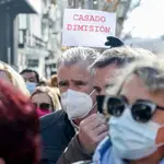Varias personas, con una pancarta que reza, &#39;Casado dimisión&#39; en una concentración de apoyo a Díaz Ayuso, en la sede del Partido Popular
