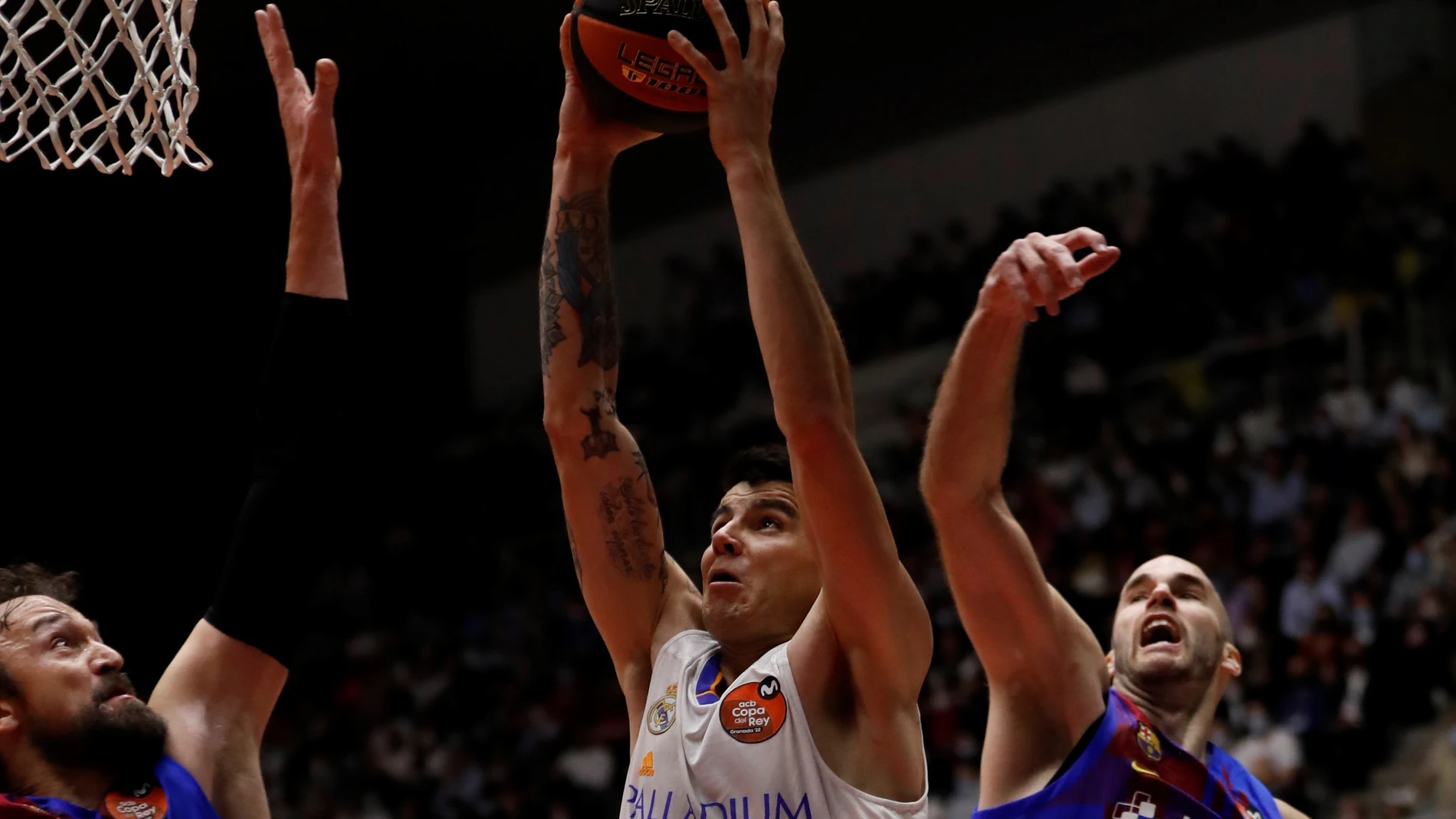 El base griego del Barcelona, Nick Calathes (d), defiende al alero argentino del Real Madrid, Gabriel Deck (c), en la final de la Copa del Rey