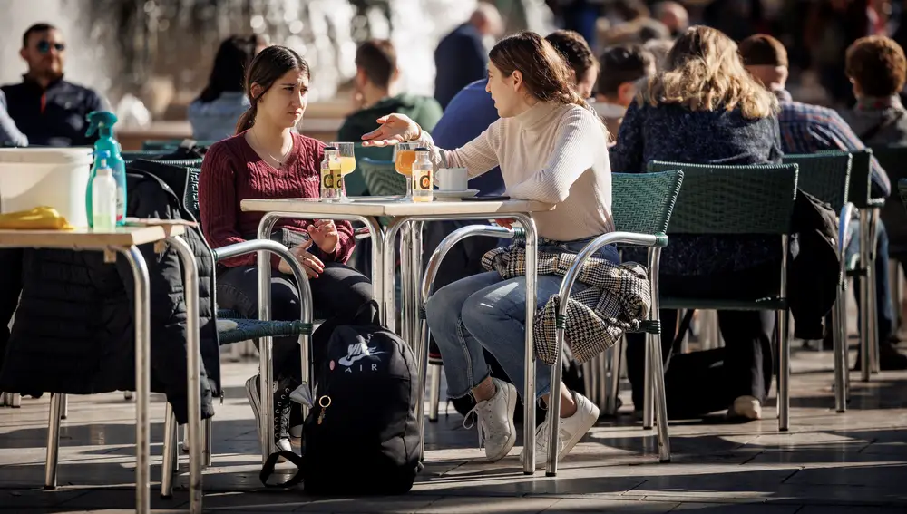 Varias personas disfrutan de un soleado día de invierno en una terraza en la ciudad de Valencia