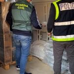 Los agentes de la Policía y la Guardia Civil revisan los fardos de droga