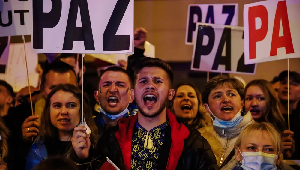 Un grupo de personas sostiene pancartas en una concentración ante la embajada rusa en Madrid tras los primeros ataques rusos registrados en Ucrania esta pasada madrugada, a 24 de febrero de 2022, en Madrid.