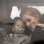 Una madre abraza a su hijo en el interior de un autobús mientras huyen de Kiev
