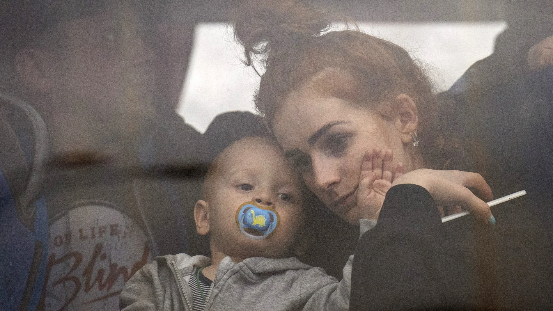 Una madre abraza a su hijo en el interior de un autobús mientras huyen de Kiev