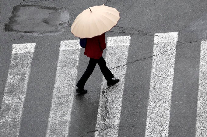 Una persona se protege del agua con paraguas cuando las lluvias caídas en la Comunitat Valenciana