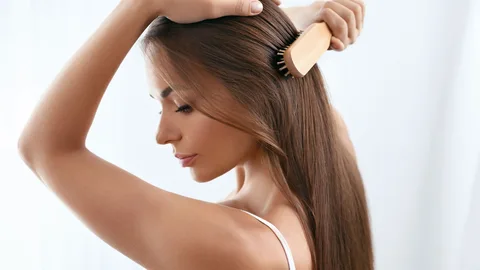 Una chica joven se cepilla el pelo