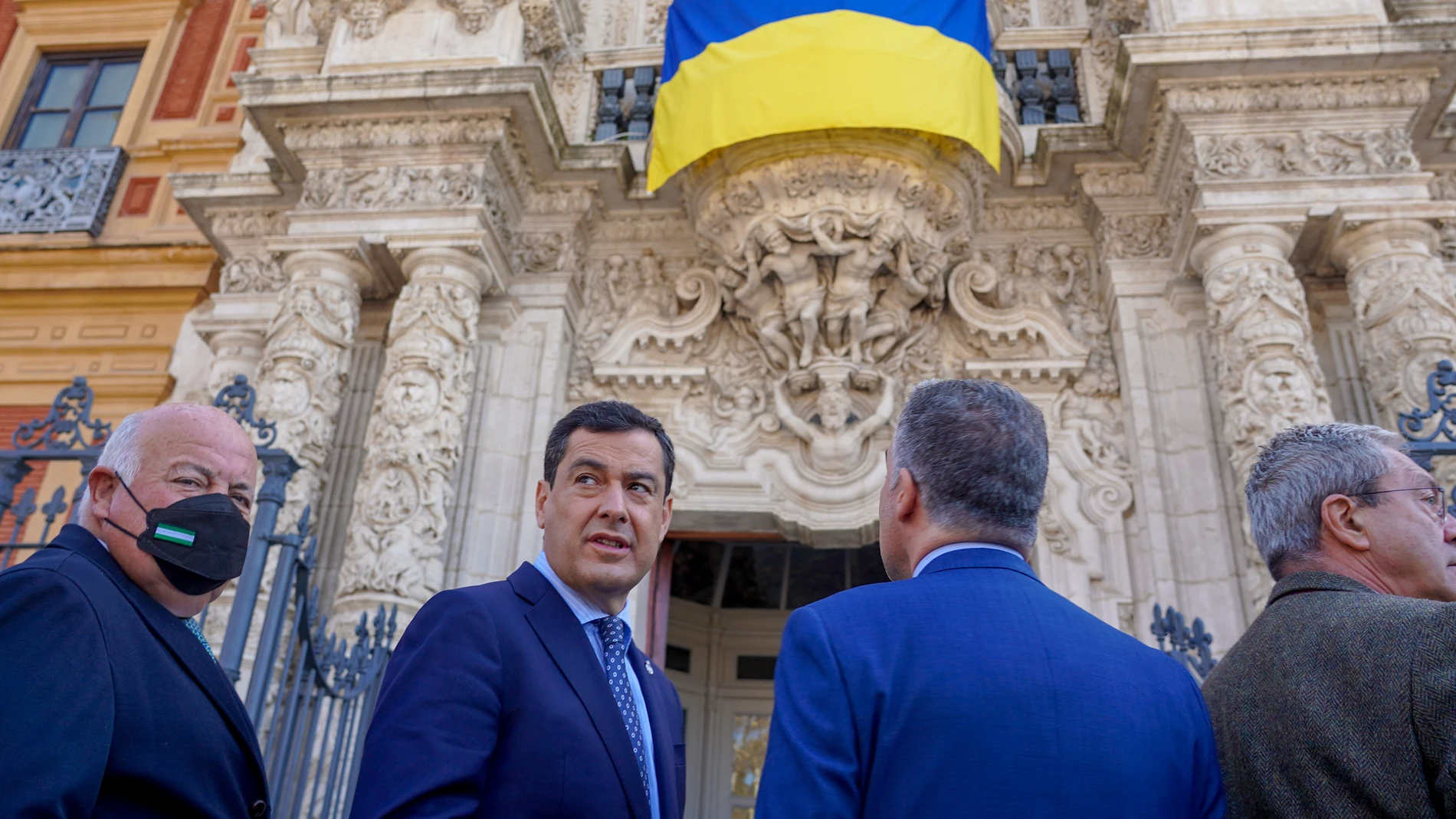 El presidente de la Junta de Andalucía, Juanma Moreno, y el resto de miembros del Consejo de Gobierno asisten a la colocación de la bandera nacional de Ucrania en la fachada principal del Palacio de San Telmo