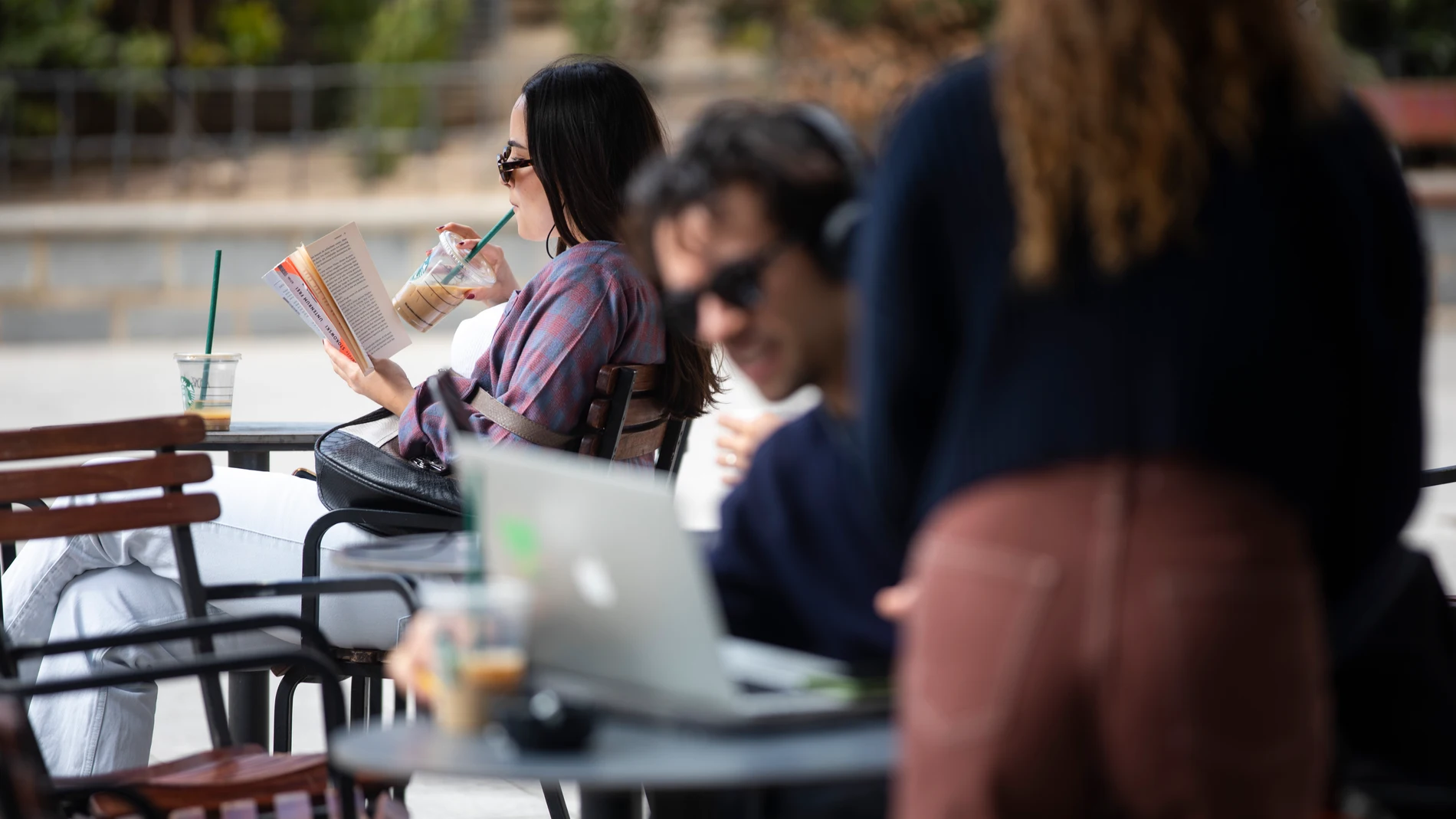 Clientes de una cafetería de Madrid leen y trabajan con el ordenador