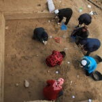 Arqueólogos excavando la superficie bien conservada del yacimiento de Xiamabei, en el norte de China, mostrando herramientas de piedra, fósiles, ocre y pigmentos rojos.
