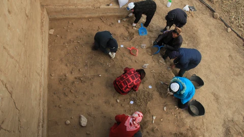 Arqueólogos excavando la superficie bien conservada del yacimiento de Xiamabei, en el norte de China, mostrando herramientas de piedra, fósiles, ocre y pigmentos rojos.