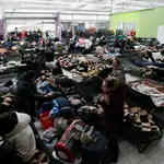 Refugiados ucranianos llegan a un centro comercial polaco, donde son atendidos y asesorados tras pasar la frontera, este jueves en Mlyny, Polonia