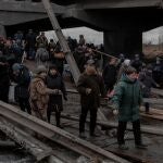 Personas cruzando un puente destruido en la ciudad de Irpin, en la región de Kiev