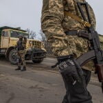 Los miembros de las Fuerzas de Defensa Territorial hacen guardia en un puesto de control, en la parte oriental de la región de Kiev
