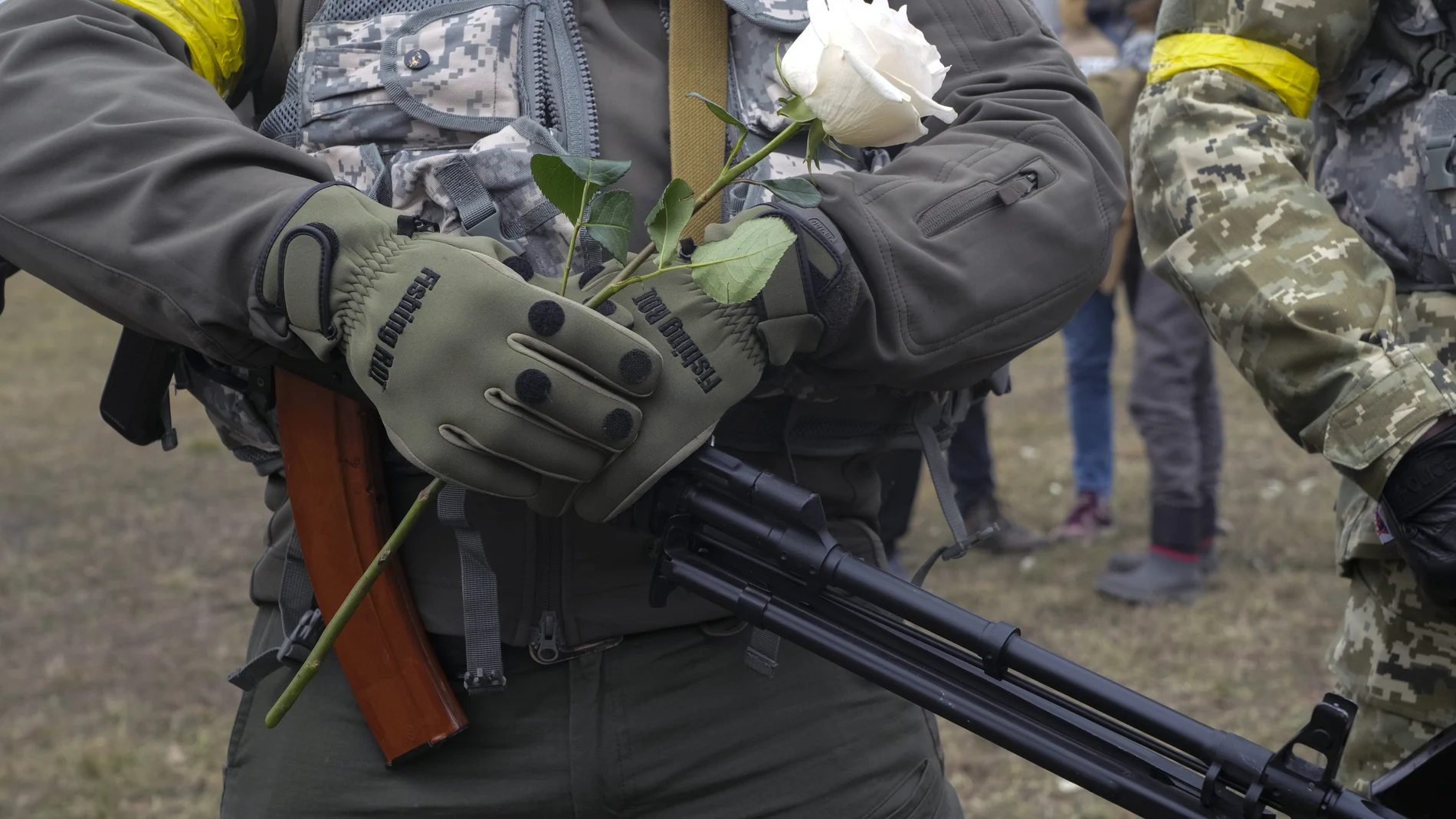 Un miembro del Ejército ucraniano sostiene una flor durante la boda de dos compañeros ayer en Kiev