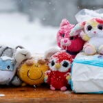 La nieve cubre los juguetes para niños y los productos de cuidado para bebés en una mesa que muestra productos de ayuda para los niños ucranianos, en el paso fronterizo de Siret (Rumanía)