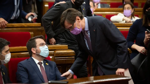 El presidente de la Generalitat, Pere Aragonès, y el primer secretario del PSC, Salvador Illa, hablan durante una sesión plenaria en el Parlament junto a Jordi Puigneró (Junts)