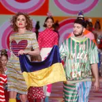 La diseñadora Ágatha Ruiz de la Prada, junto al cantante Omar Montes, porta una bandera de Ucrania tras la presentación de su colección durante la 75º edición de la Mercedes Benz Fashion Week de Madrid