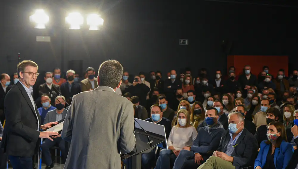 El presidente de la Xunta, y precandidato a la Presidencia del Partido Popular, Alberto Núñez Feijóo (i), escucha al presidente del PPCV, Carlos Mazón, en un encuentro con simpatizantes del partido, en el MuVIM