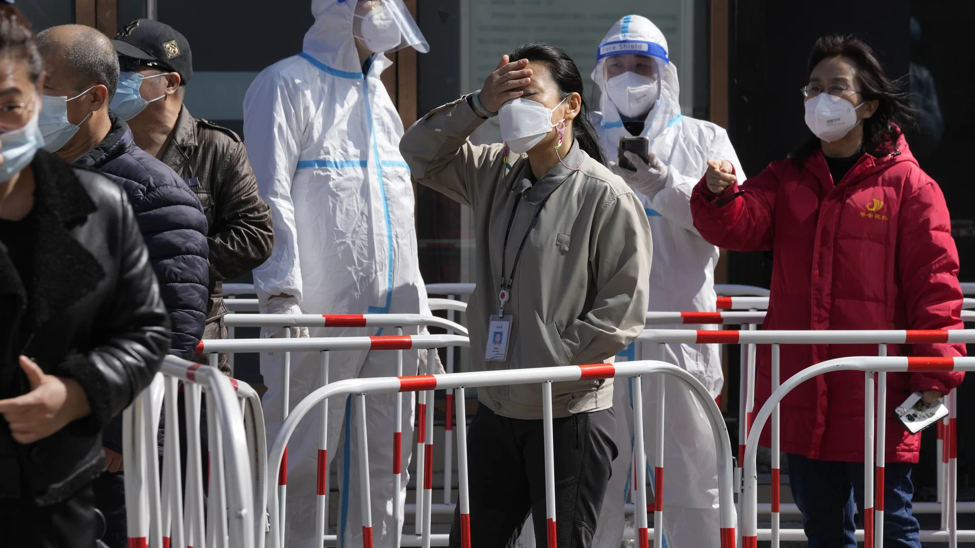 Trabajadores hacen cola para la prueba de Covid fuera de un edificio de oficinas hoy lunes 14 de marzo de 2022 en Beijing