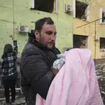 Un hombre con un bebé en la ciudad asediada de Mariupol, al sur de Ucrania