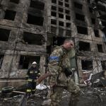 Un soldado ucraniano y un bombero en el edificio residencial atacado en Kiev