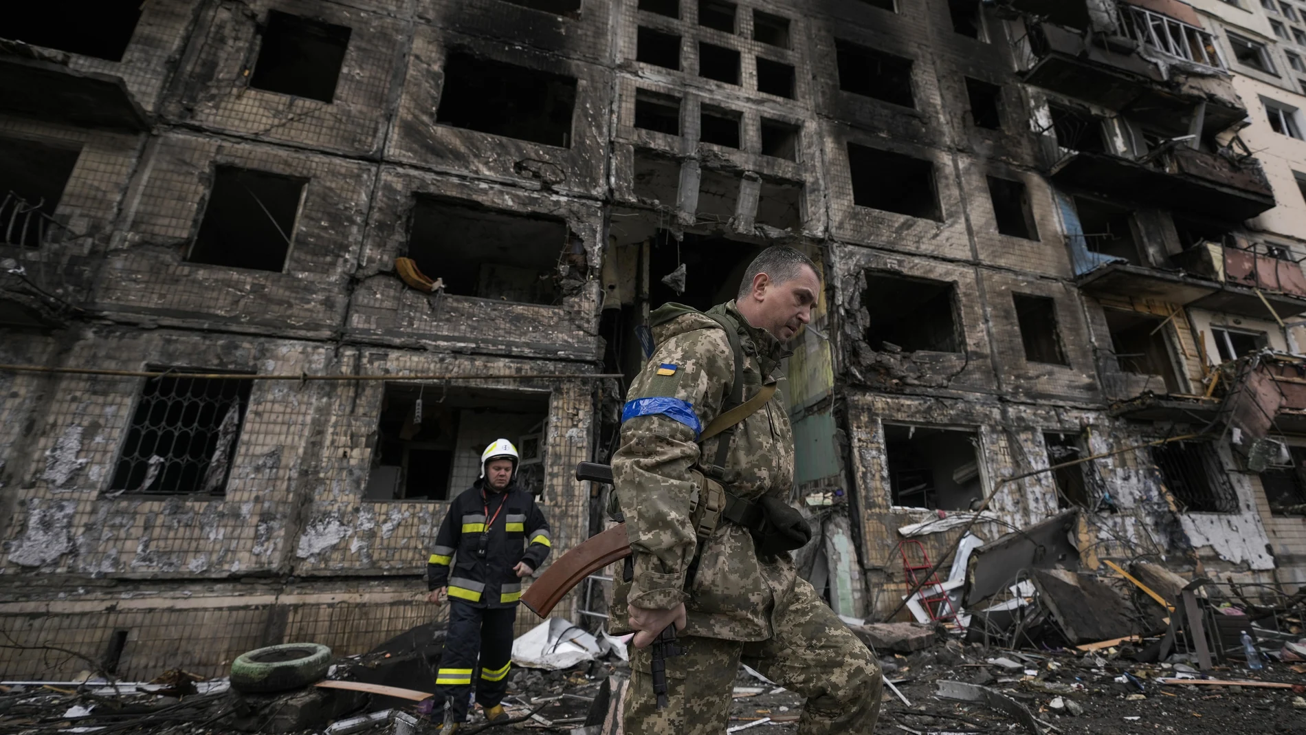 Un soldado ucraniano y un bombero en el edificio residencial atacado en Kiev