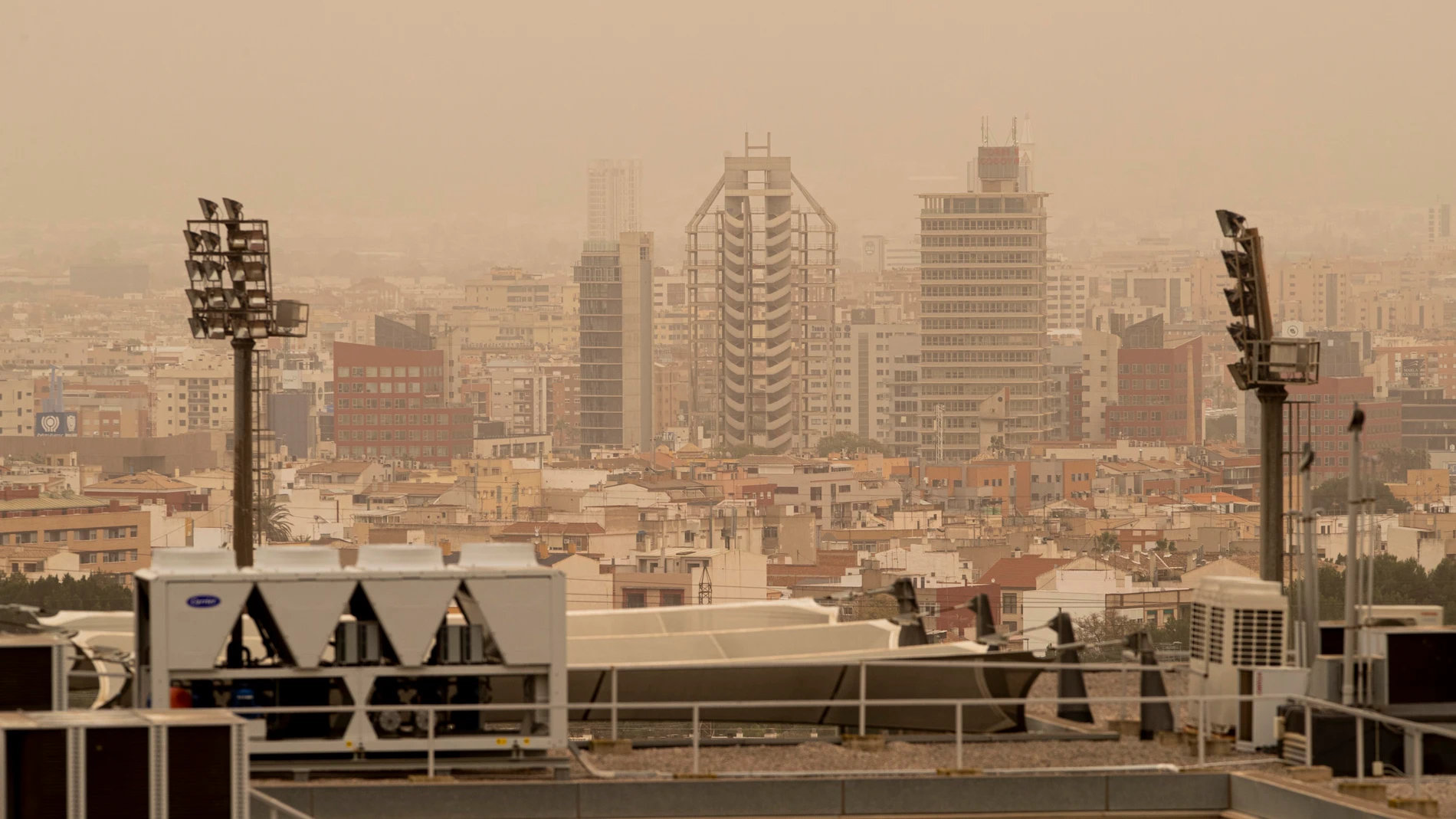 Vista de la ciudad de Murcia cubierta con una neblina de color rojo por el alto número de partículas y polvo en suspensión este martes. La llegada de una lengua de polvo en suspensión procedente del desierto del Sáhara, impulsada por los vientos de la borrasca Celia, ha elevado a la categoría de "extremadamente desfavorable" la calidad del aire en amplias zonas del país, por los altos niveles de concentración de partículas PM10, afectando seriamente a la salud.