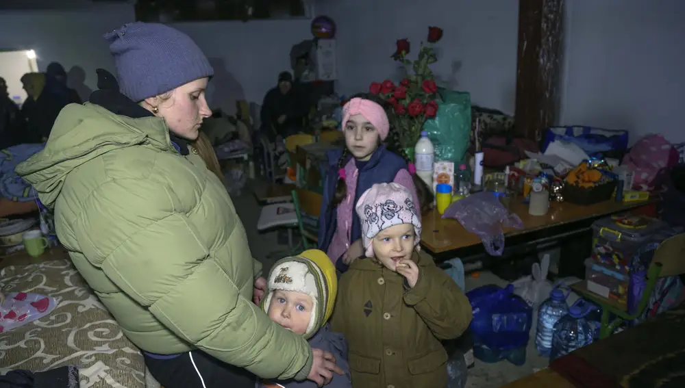 Una mujer y sus niños se protegen de los bombardeos en un refugio escolar antiaéreo en la aldea de Sartana, que está bajo el control del Gobierno de la República Popular de Donetsk
