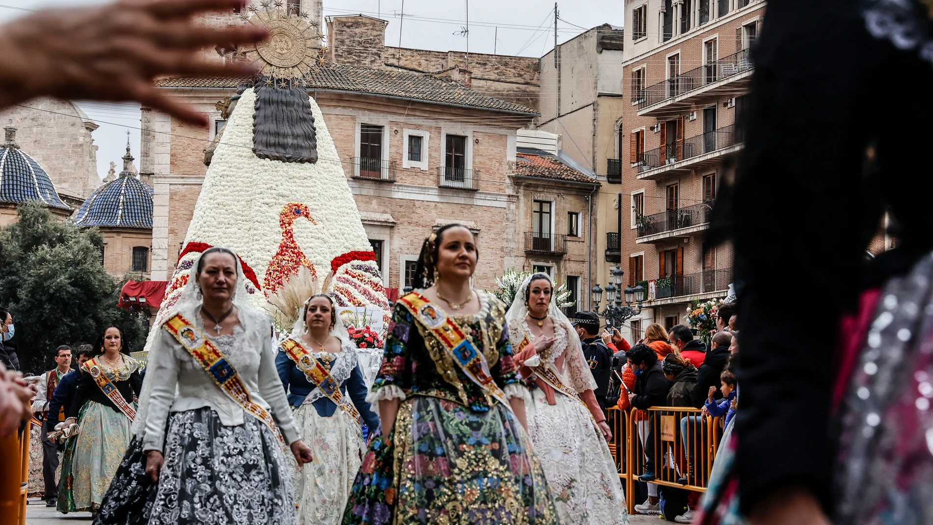 Varias falleras delante del ave fénix que forma el manto de flores de la Virgen de los Desamparados, a 18 de marzo de 2022, en Valencia, Comunidad Valenciana (España).