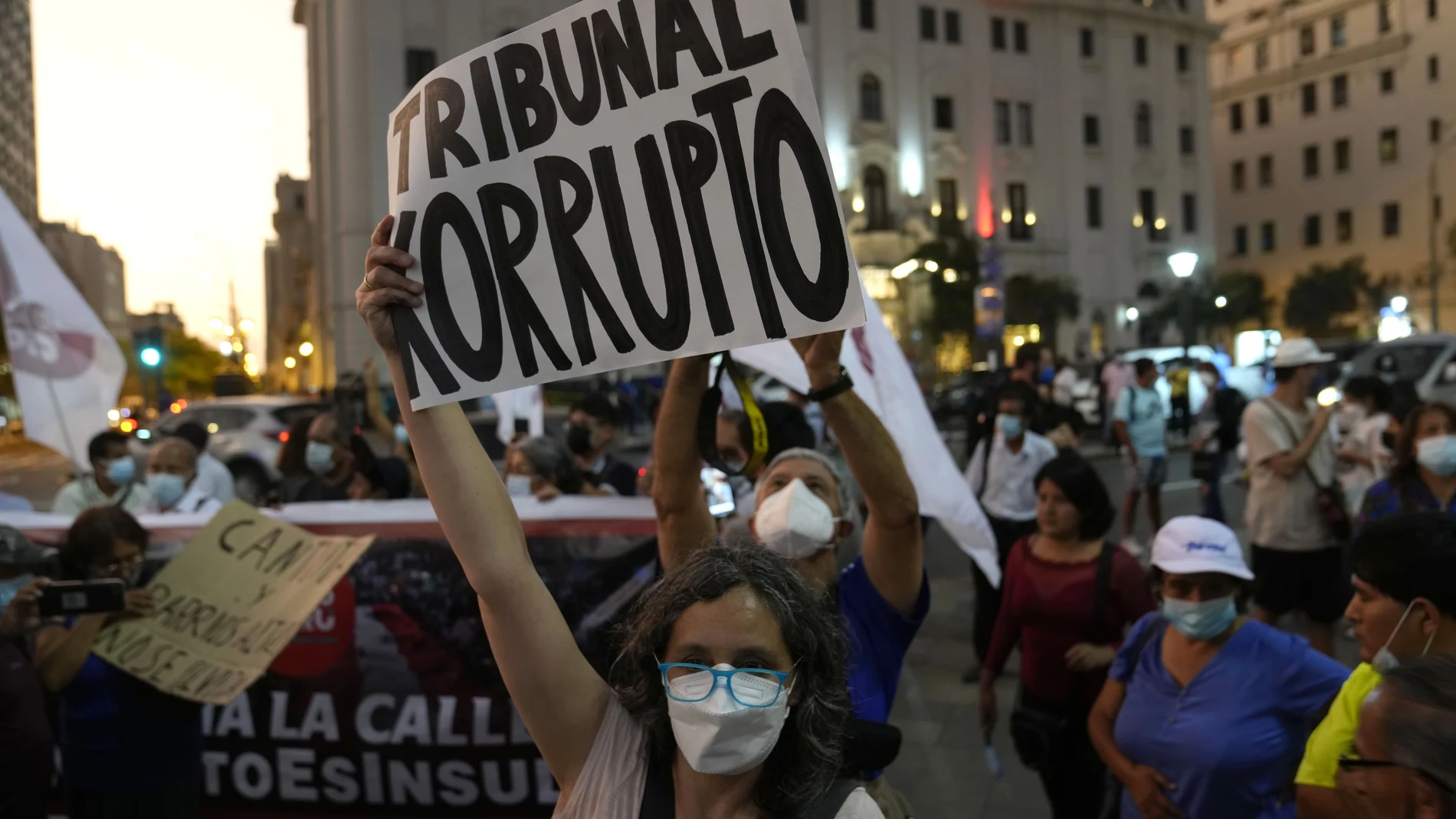 Una mujer sostiene un cartel que dice en español "Tribunal corrupto", mientras los manifestantes protestan contra la decisión de la Corte Constitucional de Perú que aprobó la liberación de prisión del expresidente Alberto Fujimori en Lima, Perú, el jueves 17 de marzo de 2022.
