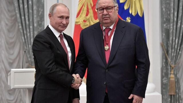 Vladimir Putin saluda al magnate ruso Alisher Usmanov, propietario de un avión privado que despegó de Munich después de las sanciones de la UE que impiden el movimiento de sus propiedad en suelo europeo