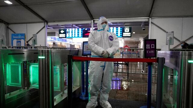Un trabajador con traje protector en la estación de tren de Shanghái tras el brote de coronavirus en la ciudad