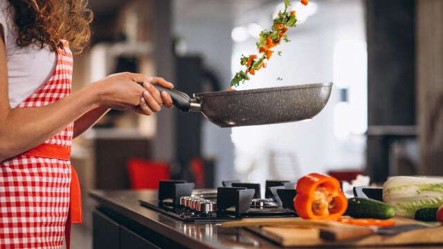 Mujer cocinando verduras en una sartén