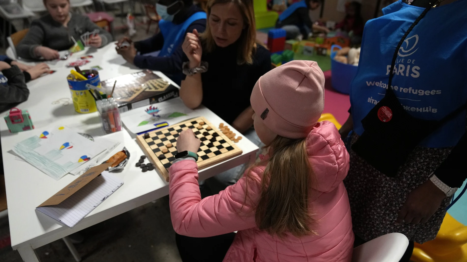 Katerina, una voluntaria ucraniana que vive en Francia, juega con una niña ucraniana en un centro que ayuda a los refugiados ucranianos con alojamiento urgente y documentos en París