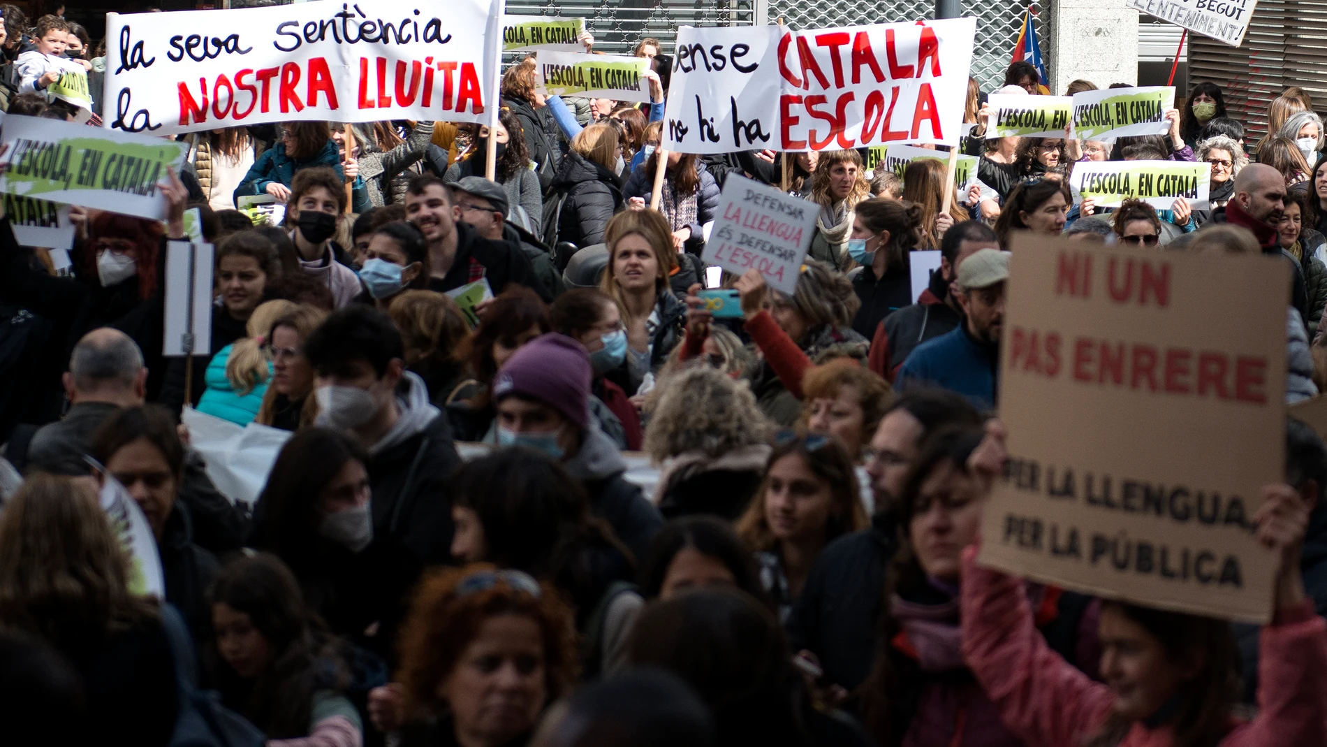 Varios manifestantes con pancartas que rezan 'Lèscola en català', en una huelga por la sentencia del 25% en castellano en la educación catalana, a 23 de marzo de 2022.