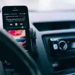 Un móvil reproduciendo música en el soporte para el coche