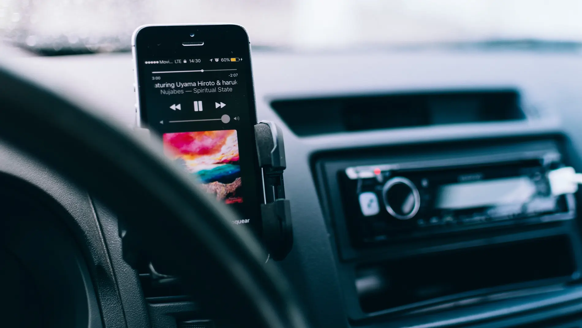 Un móvil reproduciendo música en el soporte para el coche