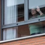 Una mujer confinada saluda desde la ventana en la Región de Murcia