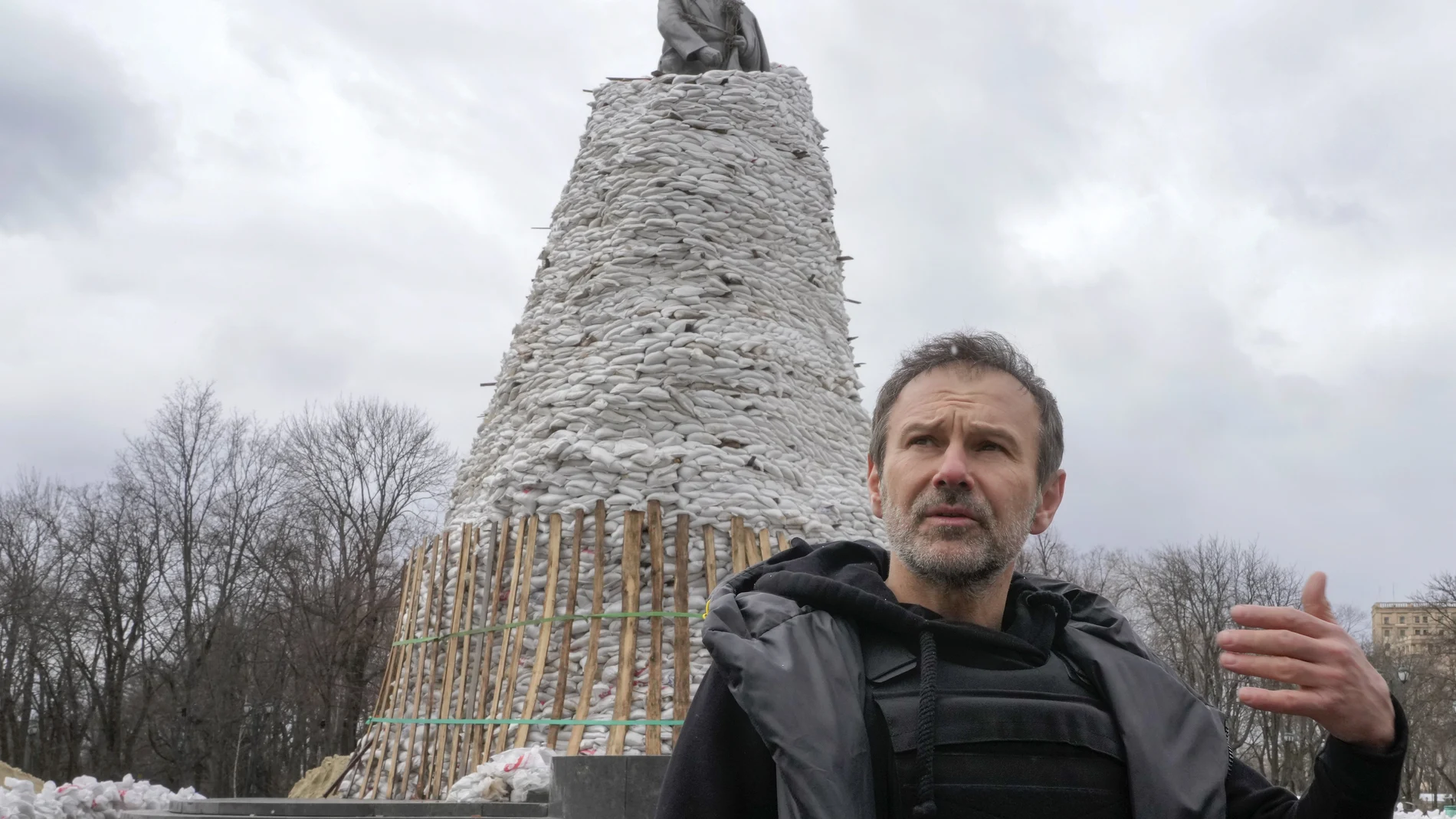 El músico ucraniano Svyatoslav Vakarchuk gesticula contra el fondo de un monumento de Taras Shevchenko, un famoso poeta ucraniano y símbolo nacional, cubierto con bolsas para protegerlo del bombardeo ruso en Kharkiv.