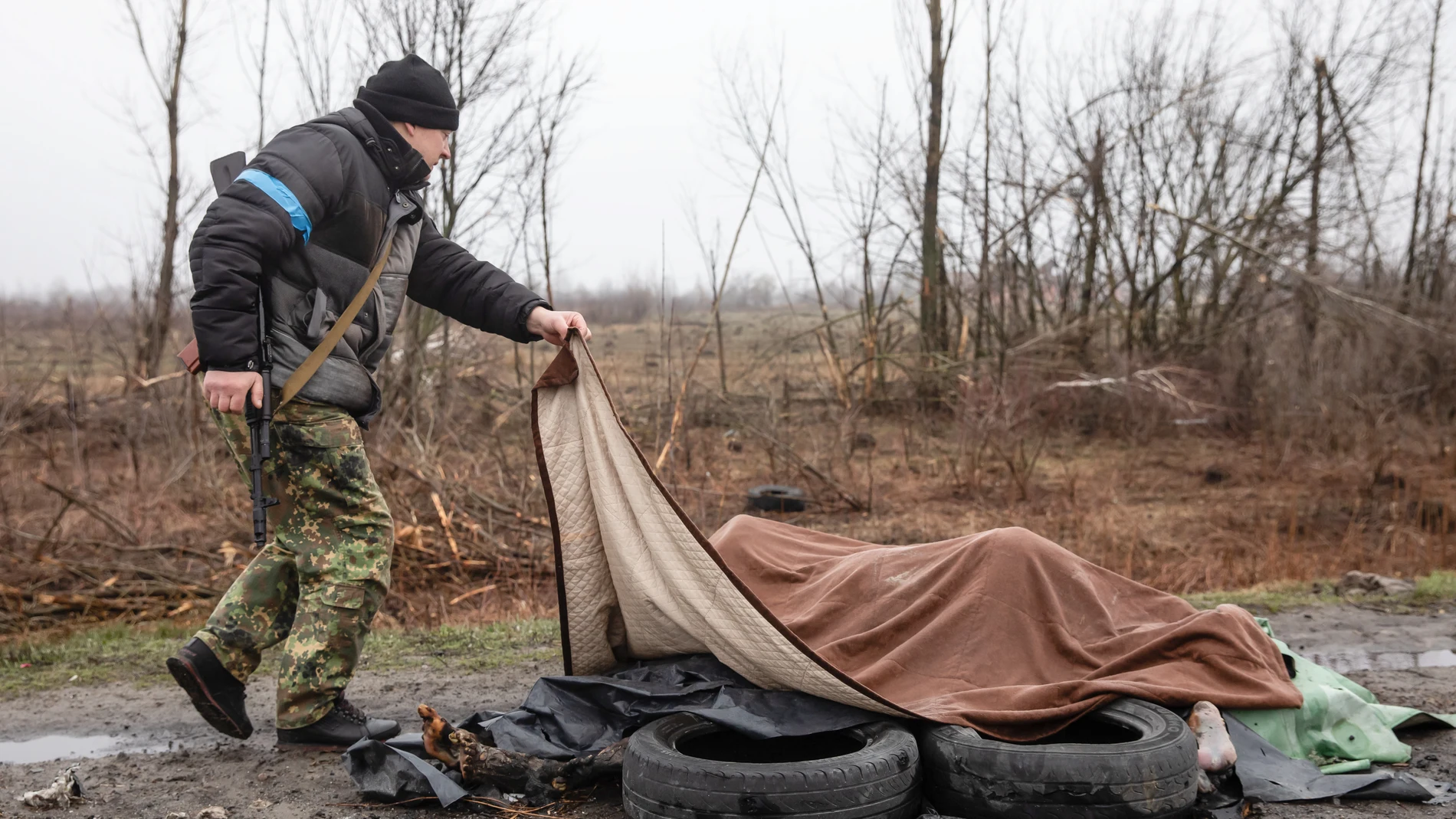 Un soldado ucraniano junto a los cadáveres de cuatro civiles asesinados por los rusos en Bucha