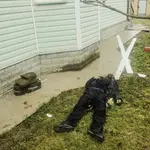 El cuerpo de un civil muerto yace en el patio de una casa en Bucha, en Ucrania