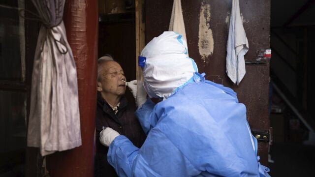Un sanitario realiza un test de antígenso a un anciano residente en Shanghái, China,