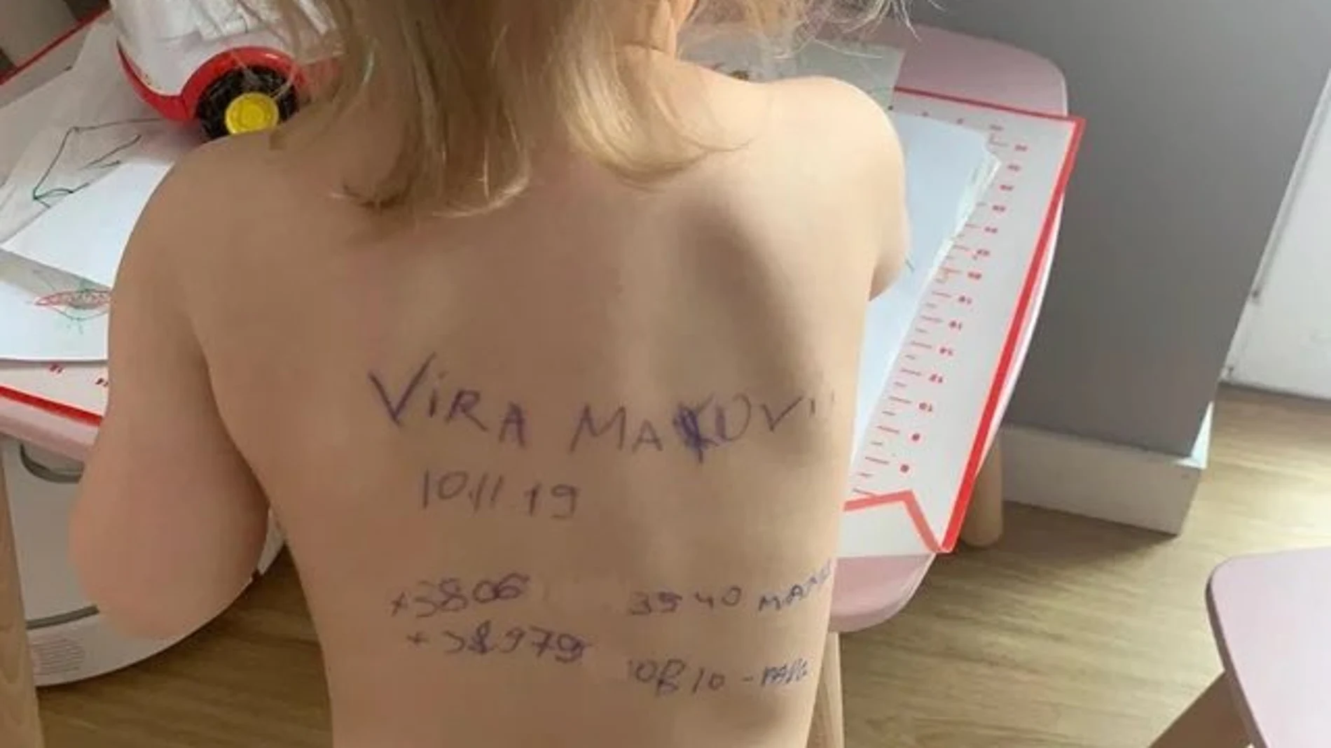 El cuerpo de un niño con datos de la familia escritos en la espalda