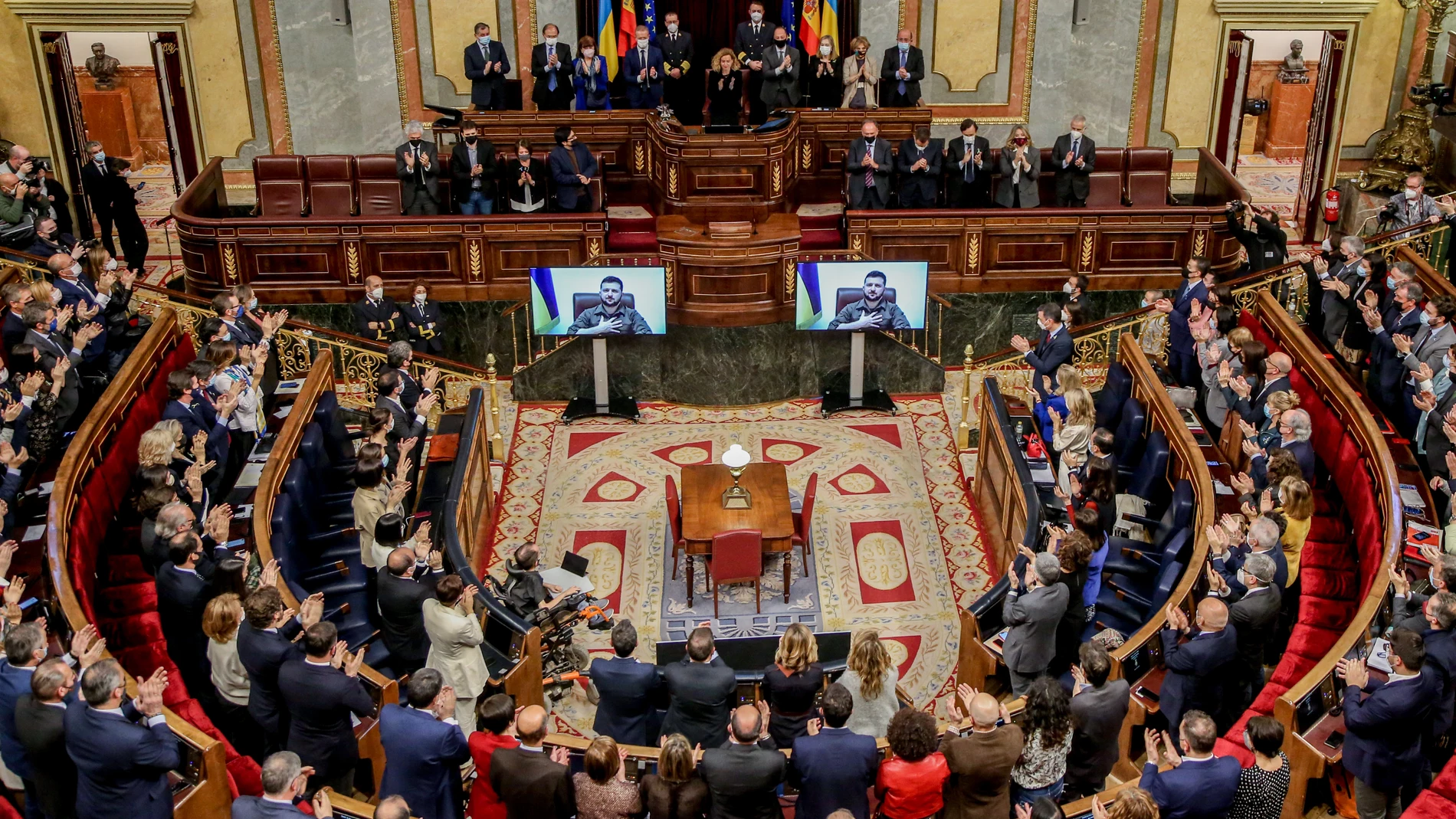 Asistentes aplauden tras la comparecencia telemática del presidente de Ucrania, Volodímir Zelenski, en el hemiciclo del Congreso de los Diputados, a 5 de abril de 2022, en Madrid.