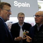 El president de la Generalitat, Ximo Puig (i), conversa con el presidente de AVA-Asaja, Cristóbal Aguado, en el stand de España durante su visita a las empresas de la Comunitat Valenciana que participan en el certamen alemán, Fruitlogistic