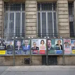 Un hombre pasa por una calle con carteles electorales en Burdeos