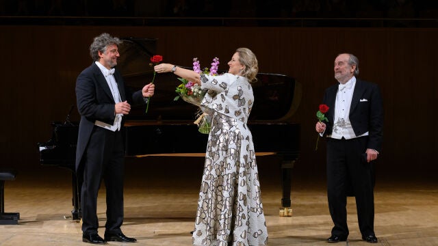 Jonas Kaufmann ofrece una rosa a la soprano Diana Damrau mientras Helmuy Deutsch observa la escena